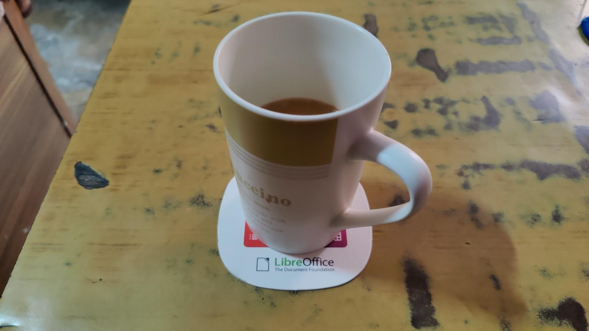A cup of tea on a coaster with LibreOffice logo on it.